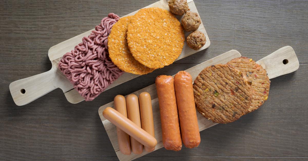 A wooden cutting board displaying healthier alternatives to Vienna sausage, featuring assorted meats, sausages, and hot dogs.